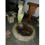 A stone birdbath, having a figural study