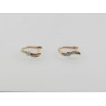 A pair of 14 carat rose gold and diamond hoop earrings.