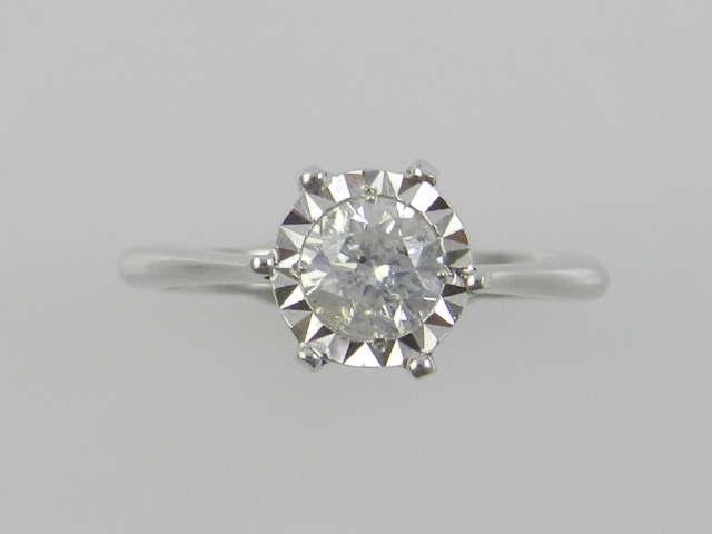 A white metal and solitaire diamond ring, the stone of approx. 0.64 carats, the shank stamped 750.