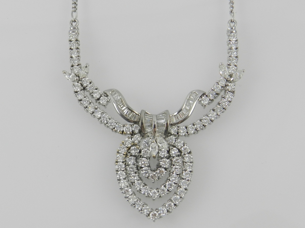 An 18 carat white gold diamond set pendant necklace fashioned as a bow and set with brilliant and