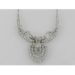 An 18 carat white gold diamond set pendant necklace fashioned as a bow and set with brilliant and