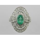 A Belle Epoque style of emerald and diamond mounted dress ring, oval cluster form, the shank stamped