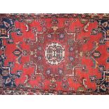 A Persian rug, with a central liver colo