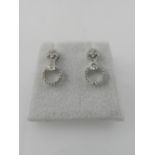 A pair of 18 carat white gold screwback earrings, set round cut cluster diamonds, above princess cut