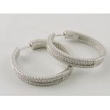 A pair of white metal hoop earrings, hal