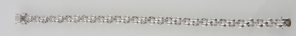 A diamond set line bracelet, with an arr