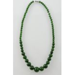 A dark green jade necklace, of graduated