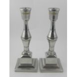 In the Art Deco style, a pair of silver plated table candlesticks, having segmented bodies raised on