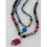 A pink and black faceted agate bead necklace with pendant, together with a turquoise and red bead