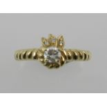 A yellow metal and single stone diamond ring with half rope twist mount, the shank stamped 10K.