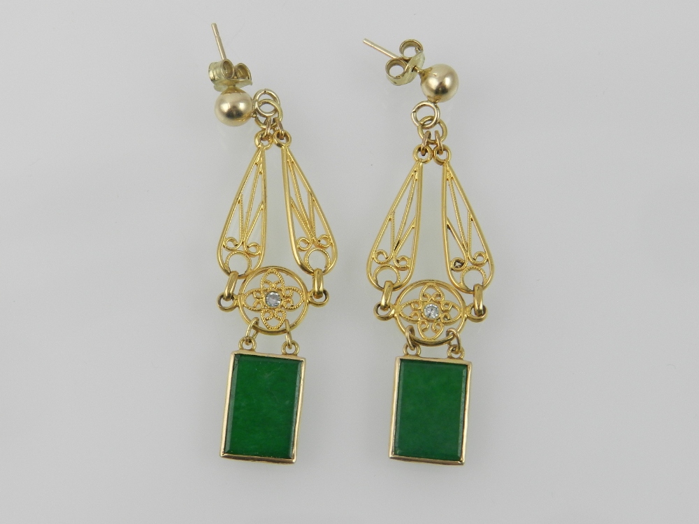 An unusual pair of yellow metal, green j