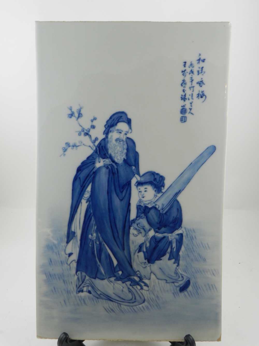A Chinese blue and white porcelain plaque, painted with elderly man and child in landscape with