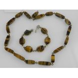 A tigers eye beaded necklace, together with a white metal and tigers eye segmented bracelet. (2)