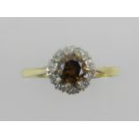 A yellow metal and diamond cluster ring, set central cognac diamond of approx. 0.4 carats, the shank