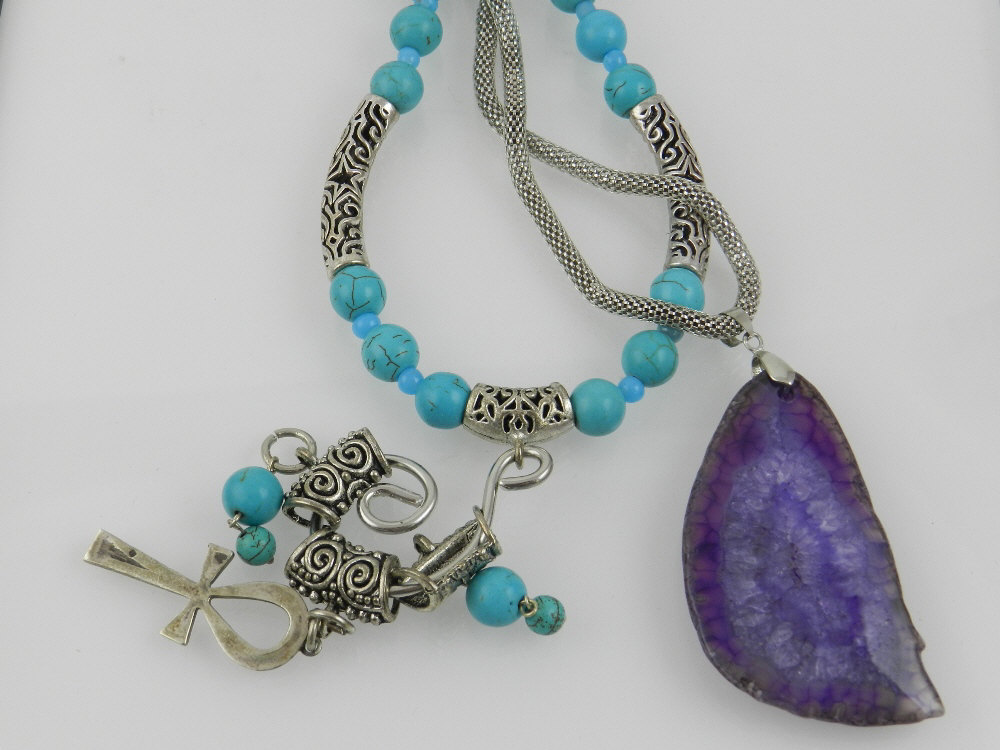 A purple agate pendant suspended on a white metal chain, the clasp with white metal Egyptian