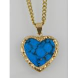 A yellow metal mounted turquoise heart-shaped pendant, suspended on a yellow metal chain.