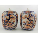 A pair of late 19th / early 20th century Japanese hard paste porcelain jars and covers, decorated in