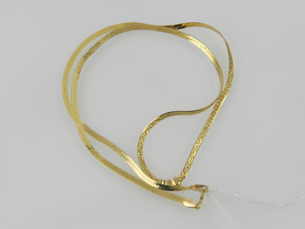 A yellow metal flattened snake link neck
