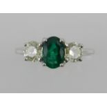 An 18 carat white gold, diamond and emerald three stone ring.