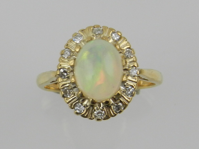 An 18 carat yellow gold, diamond, and opal cluster ring.