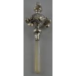 A white metal child's teether, fitted with mother-of-pearl and bells and incorporating a whistle,
