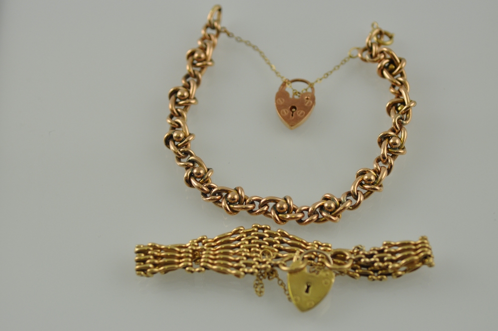 A gate-link yellow metal bracelet with a heart-shaped locket stamped 9ct; together with a similar