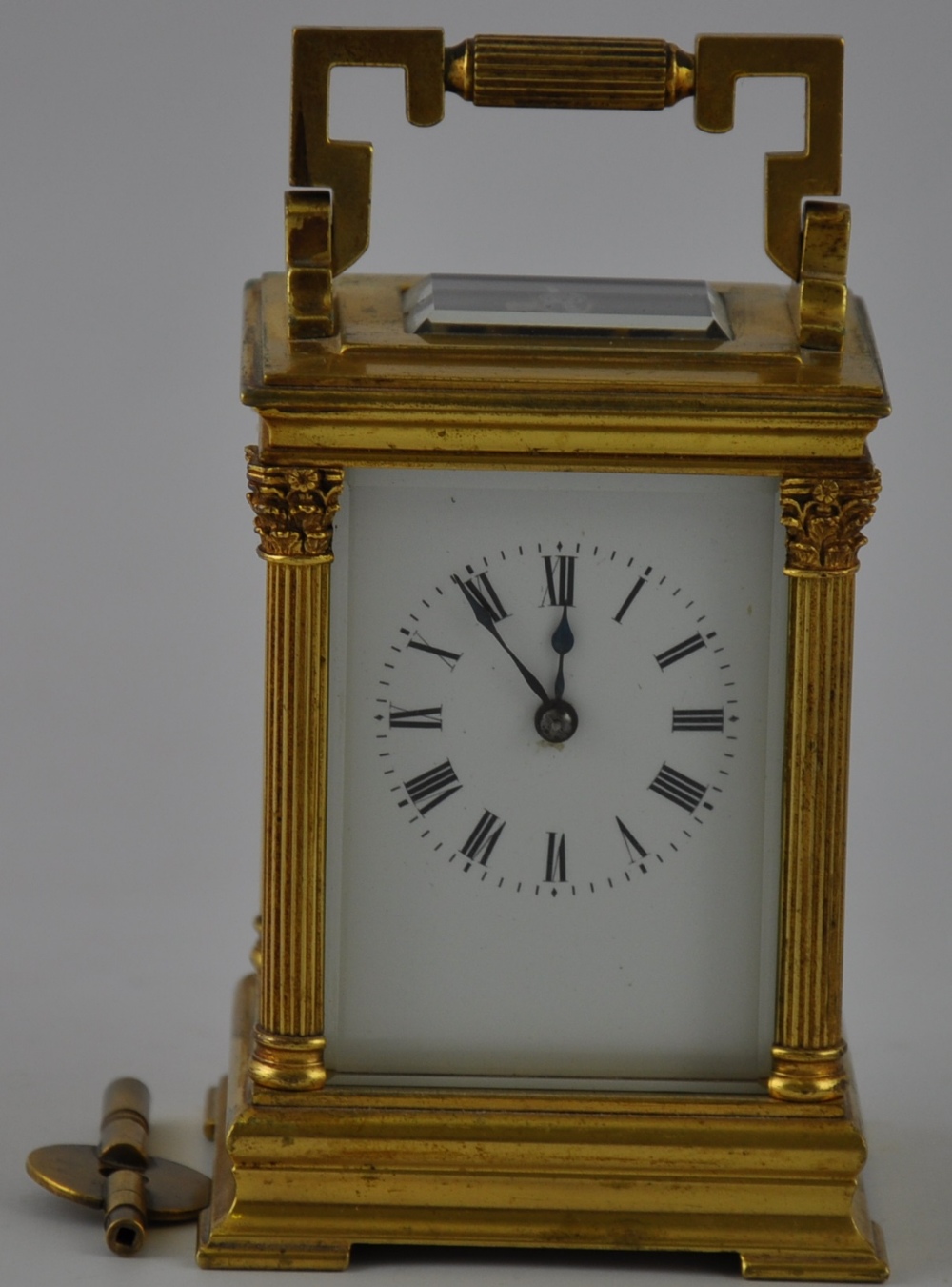 An early 20th Century carriage clock, the case with fluted acanthus columns, the white enamel dial