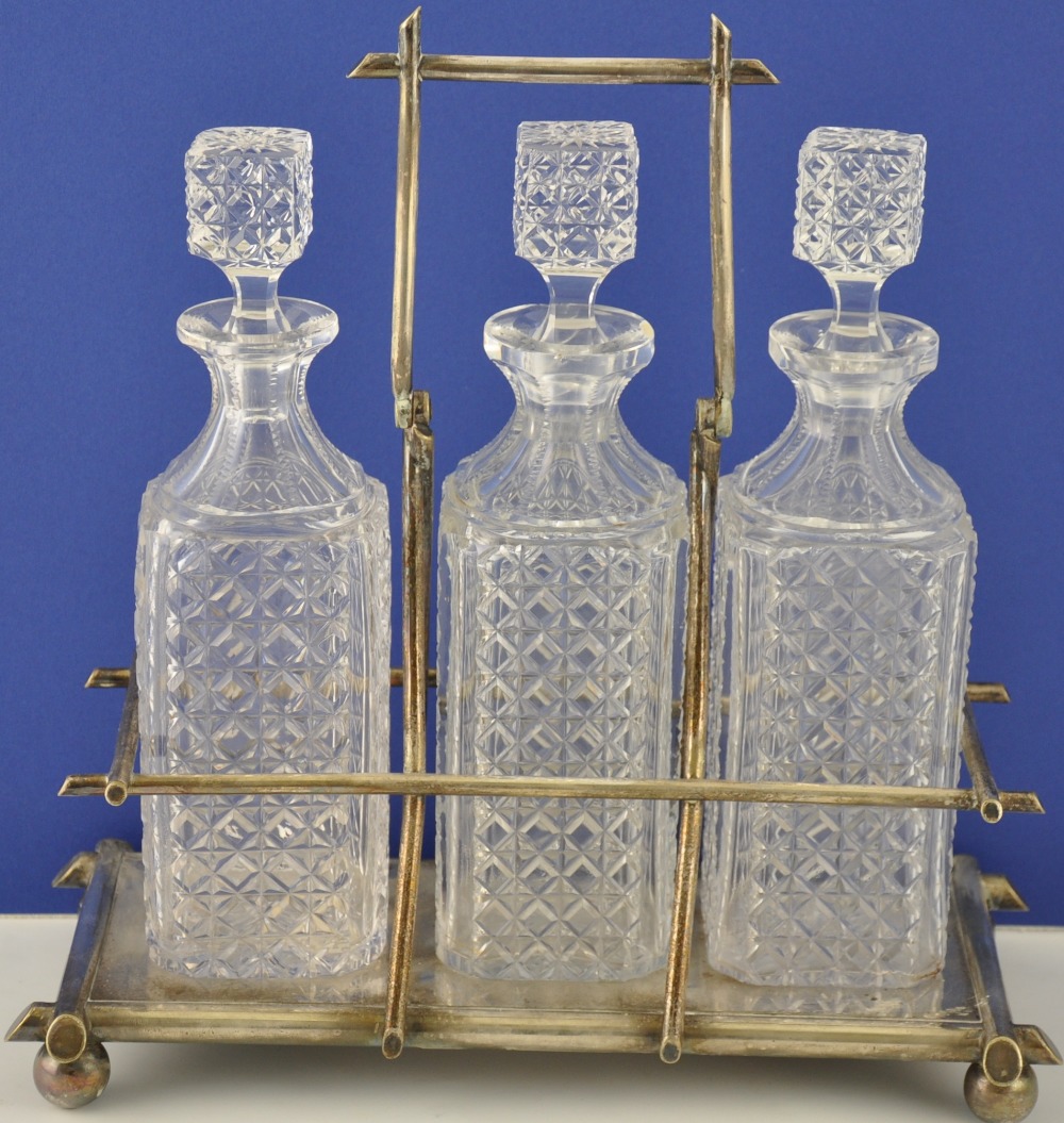 A Victorian silver plated three bottle tantalus by R Richardson, Sheffield, fitted with square cut