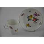 A 19th century Meissen cabinet cup and saucer, decorated with sprigs of flowers on a cream ground,