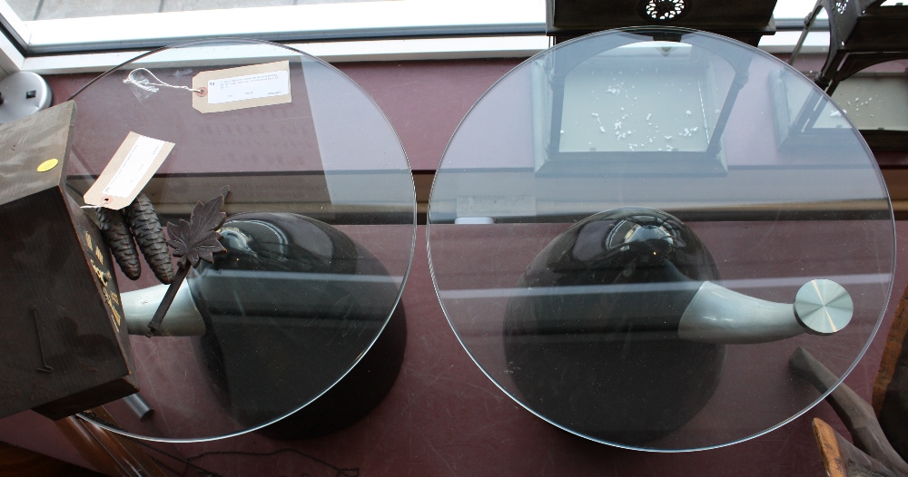 A pair of metal occasional tables modelled as aircraft nose cones with circular glass tops, Dia.