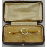 An early 20th century knife bar brooch, set with a peridot and mother-of-pearl hoop, stamped 9ct,