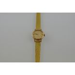 An Omega ladies' wristwatch, the gold-coloured oval dial set out in batons, on woven metal strap