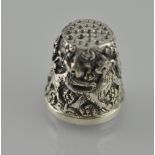 A white metal thimble, extensive repoussé decoration depicting dogs at play, stamped 925.