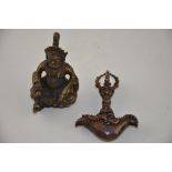 A cast bronze Tibetan Buddhist figure, together with a similar charm. (2)