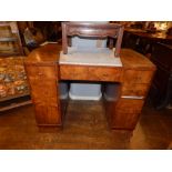 An Art Deco period figured and burr walnut pedestal desk, having a cream leather skiver to top,
