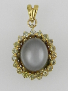 A yellow metal moonstone and diamond cluster pendant.