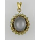 A yellow metal moonstone and diamond cluster pendant.