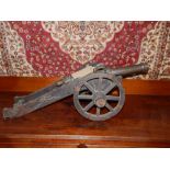 A miniature scale model of a bronze 17th century signal canon, raised on a metal mounted oak