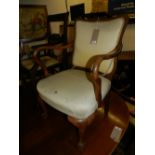 A 1920's walnut elbow chair raised on claw and ball feet.