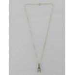 An Art Deco style white metal and diamond set pendant, having belcher link chain.