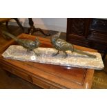 A French Art Deco period patinated bronze group, studies of fowl, raised on a variegated rouge