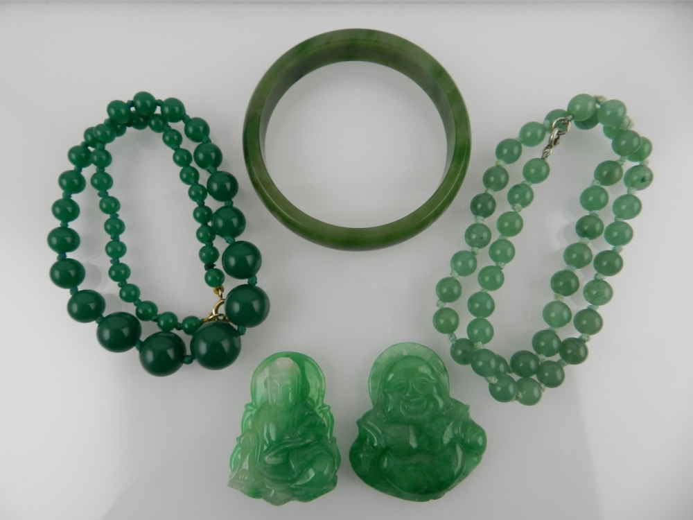 A collection of green hardstone items, to include a bangle, a beaded necklace and  two carvings