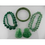 A collection of green hardstone items, to include a bangle, a beaded necklace and  two carvings