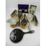 A five piece silver and tortoise shell dressing table set, inlaid with silver floral garlands,