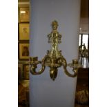 A near matching set of four French polished gilt brass two and three branch wall sconces, in the