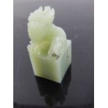 A Chinese carved jade study of a Shi Shi, raised on a square plinth base. H: 6.5cm