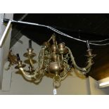 A brass chandelier, having eight scrolling arms