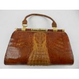 A brown leather crocodile evening bag, detailed with gilt metal.