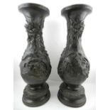 A pair of Chinese bronze vases decorated with stylised dragons. H.47cm