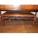 An early 20th century Chinese carved hardwood low table, with a pierced and moulded frieze raised